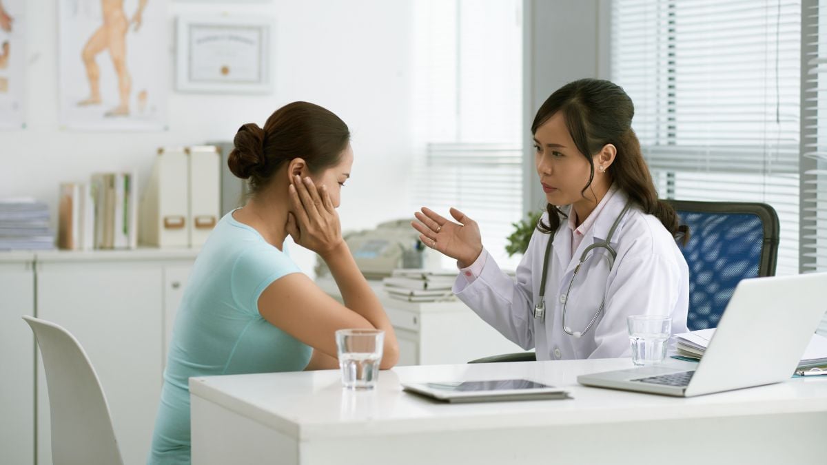 Doctor assessing a patient's facial features during a dermatological consultation