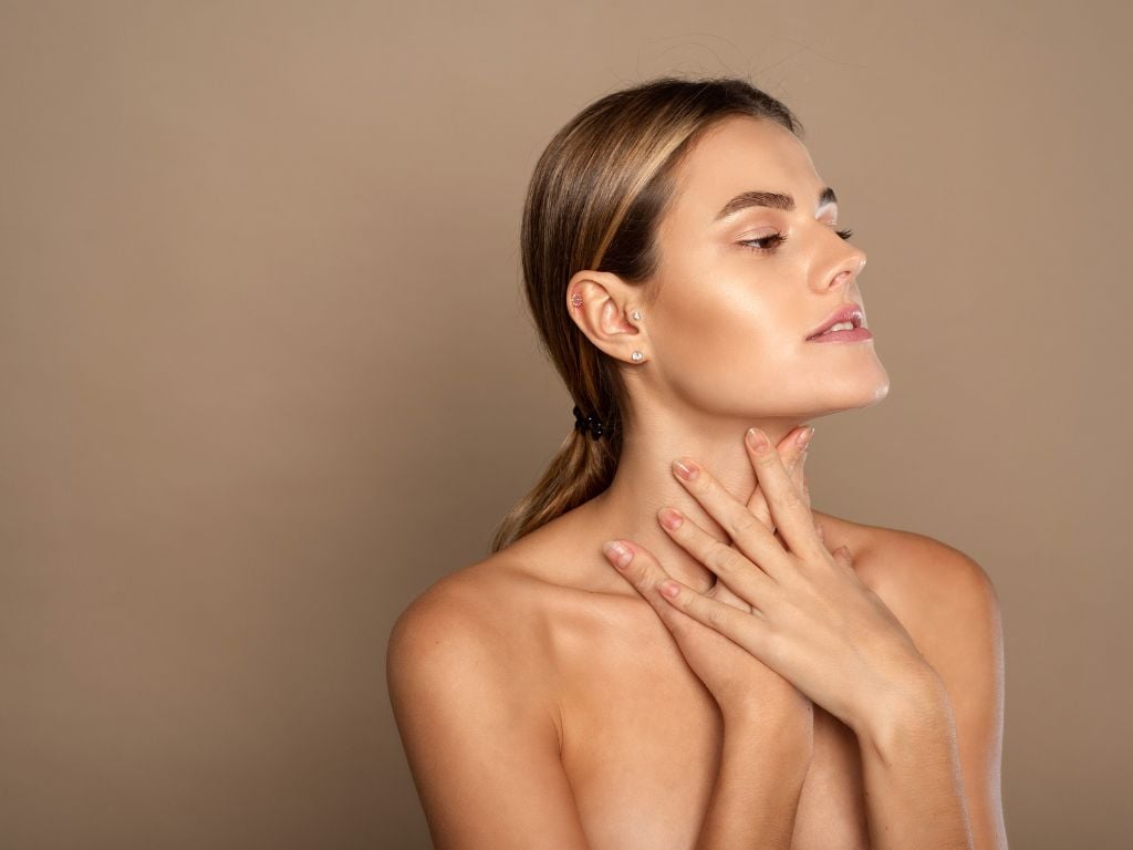 Young woman caring for the skin of her neck and décolletage